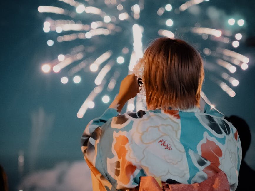 a woman in a kimono looking at fireworks