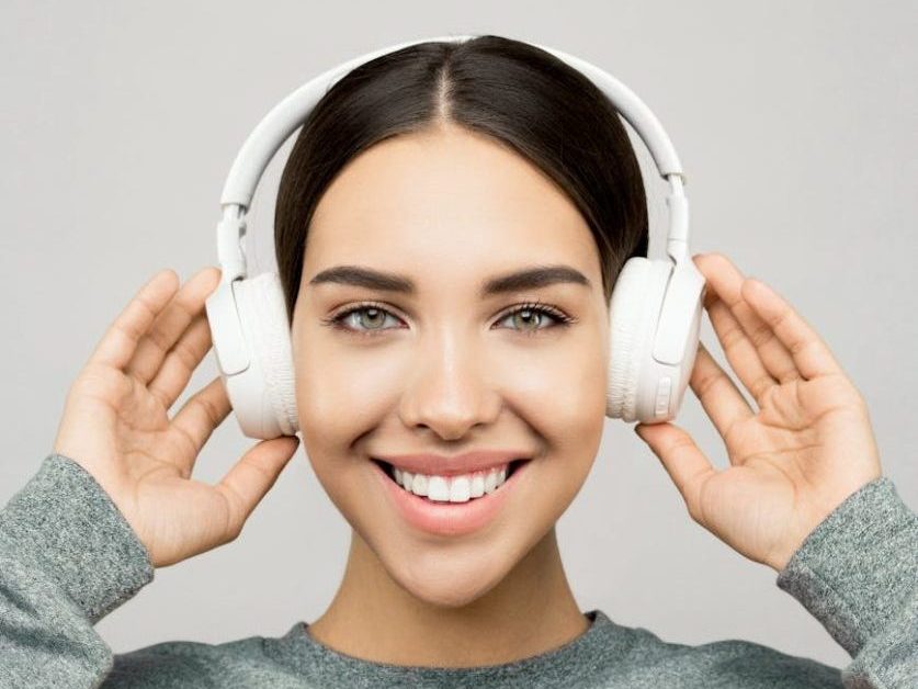 woman holding a white headphones