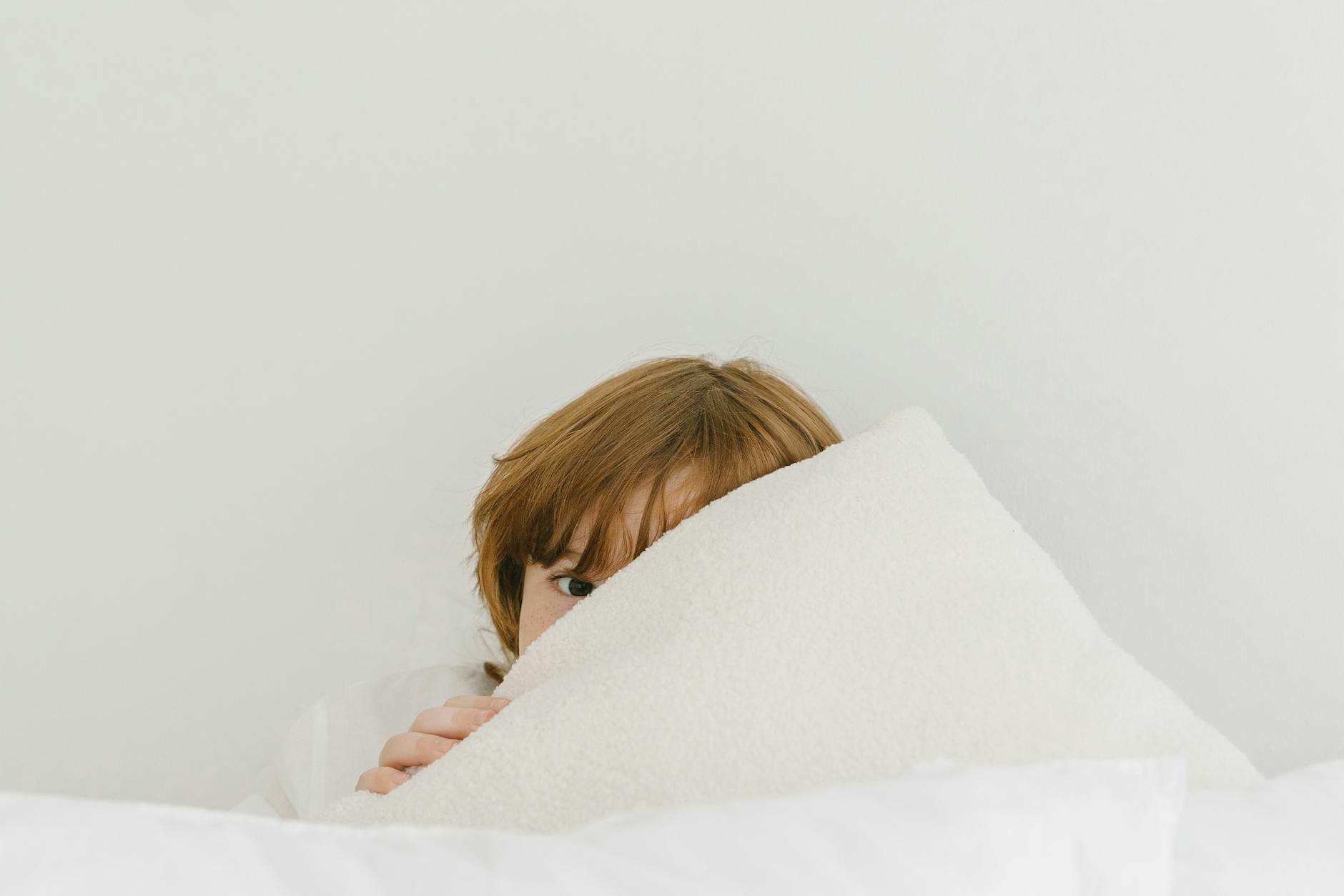 close up shot of a boy covering his face with a towel